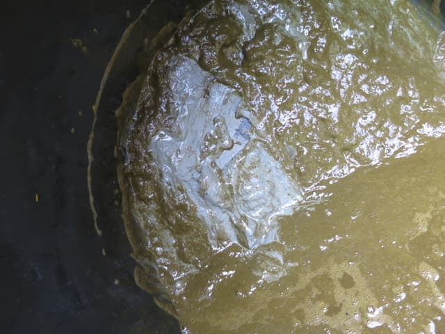Oberfläche einer Güllegrube mit aufgebrochener Schwimmdecke